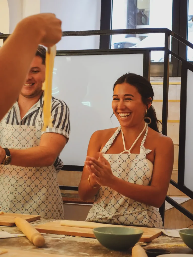 Close-up of two young chefs kneading pasta dough on a Pasta and Tiramisu cooking class in Rome