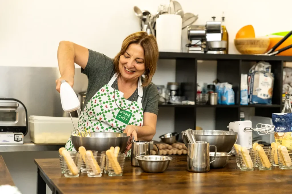 Friends gathered around table enjoying food and wine during Pizza & Tiramisu Class celebration