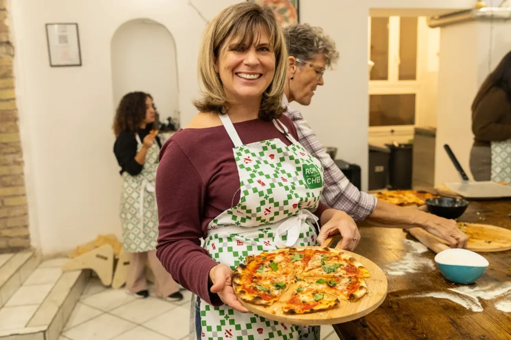 Woman smiling while enjoying meal at restaurant table during Pizza & Tiramisu Class food tour