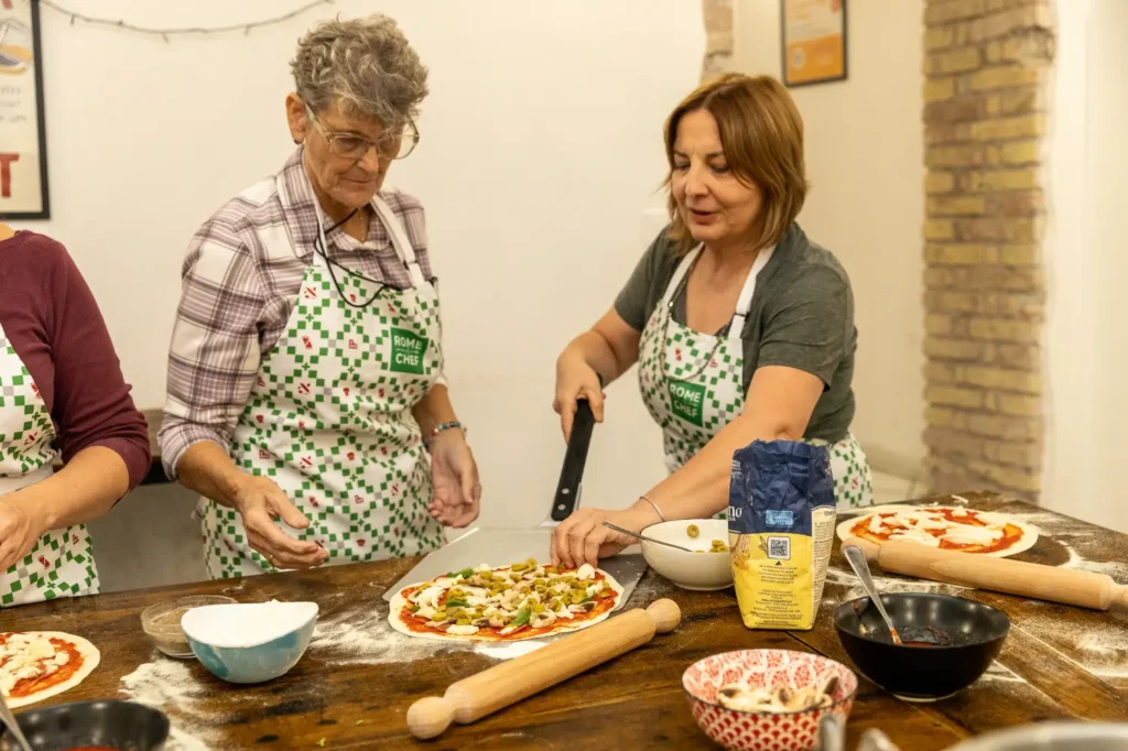 Two women preparing fresh pasta together during Pizza & Tiramisu Class cooking class