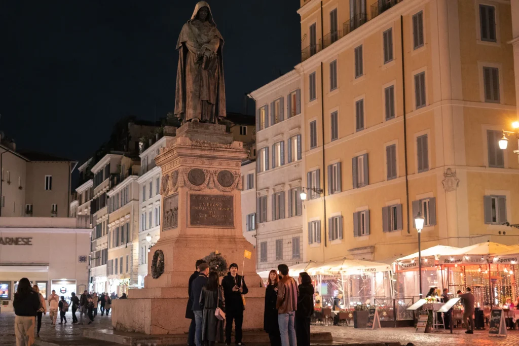 The dark statue of Giordano Bruno in Campo de' Fiori at night, a key stop on the Rome ghost tour.