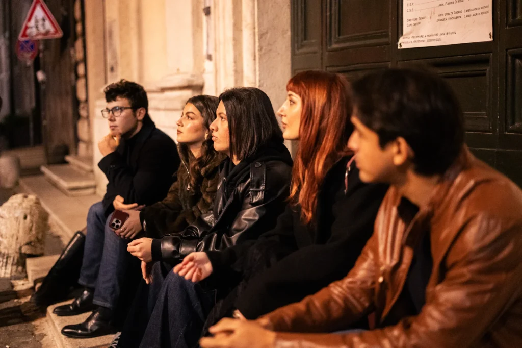 An engaged audience listening intently to a guide during a captivating Rome ghost tour.