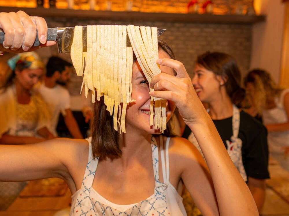 Holding up homemade fettuccine one of the most popular types of pasta in Italy
