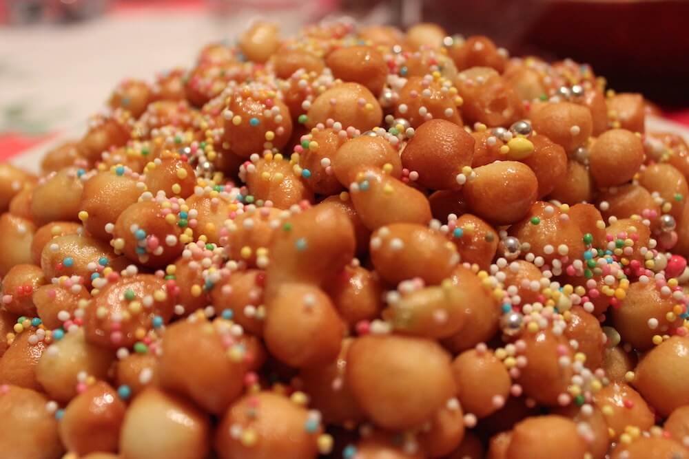 A plate of Struffoli: deep-fried dough balls glazed in honey, cinamon and more. Image CreditL Luca. https://www.flickr.com/photos/fofa81/with/11647930014