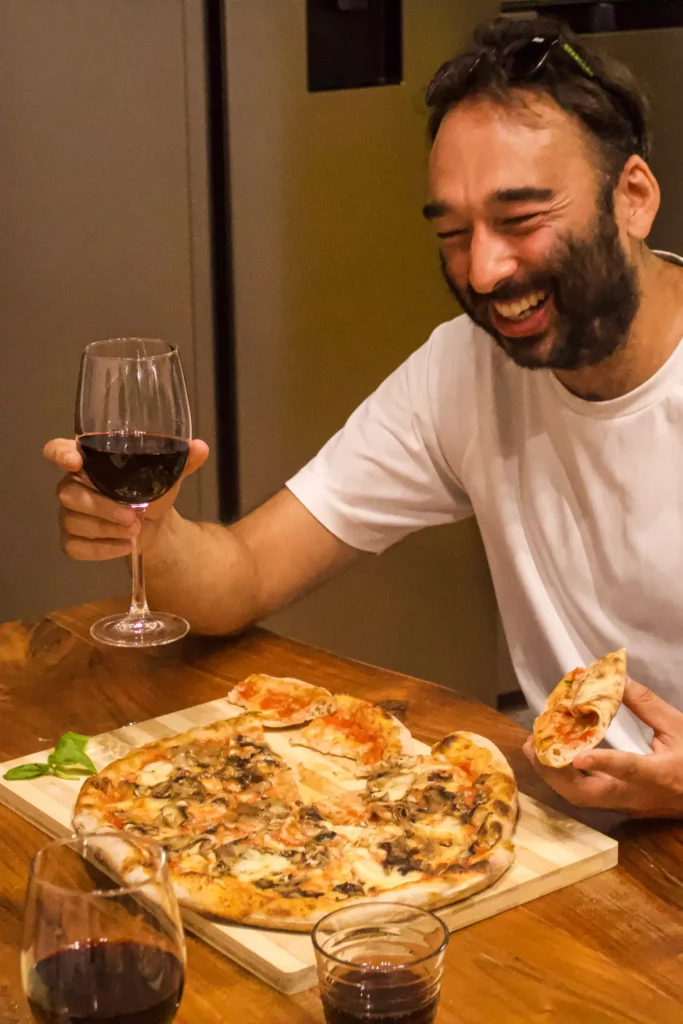 Client enjoying homemade pizza and local wine on a pizza & cocktail making class in Rome