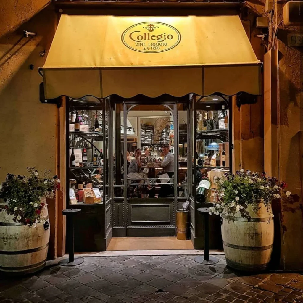 The charming entrance to Collegio, a fine dining restaurant in Rome, illuminated at night.