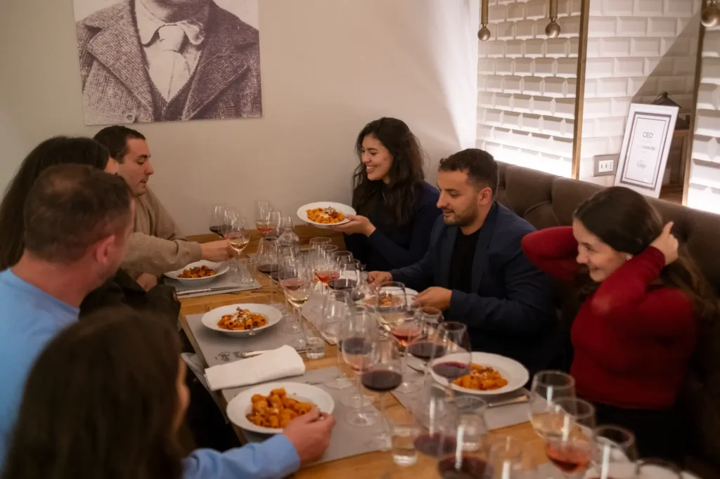 A group of friends enjoying delicious Italian pasta and wine at a fine dining restaurant.