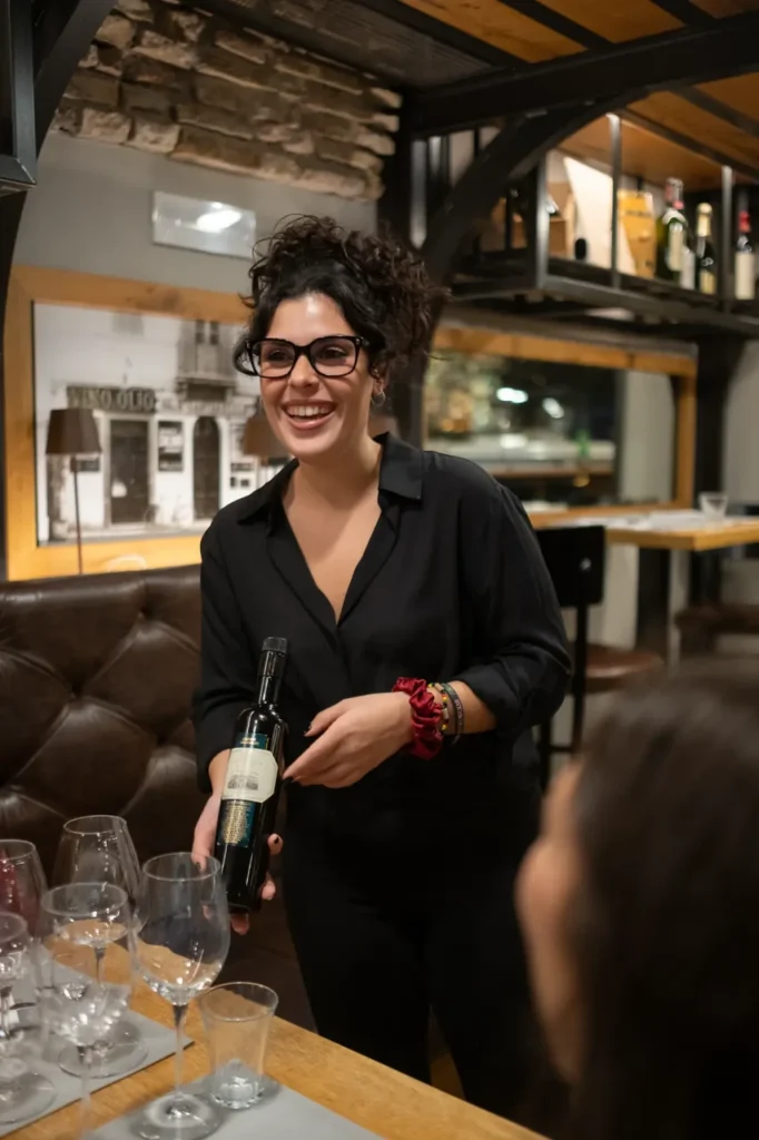 A professional sommelier presenting a bottle of fine Italian wine to guests at a restaurant during a private gourmet dinner in Rome.