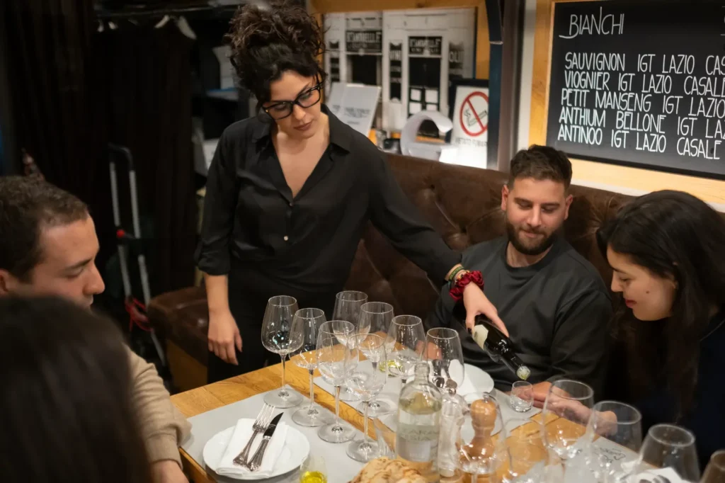 A sommelier pouring wine for a couple during an intimate privavte gourmet experience.