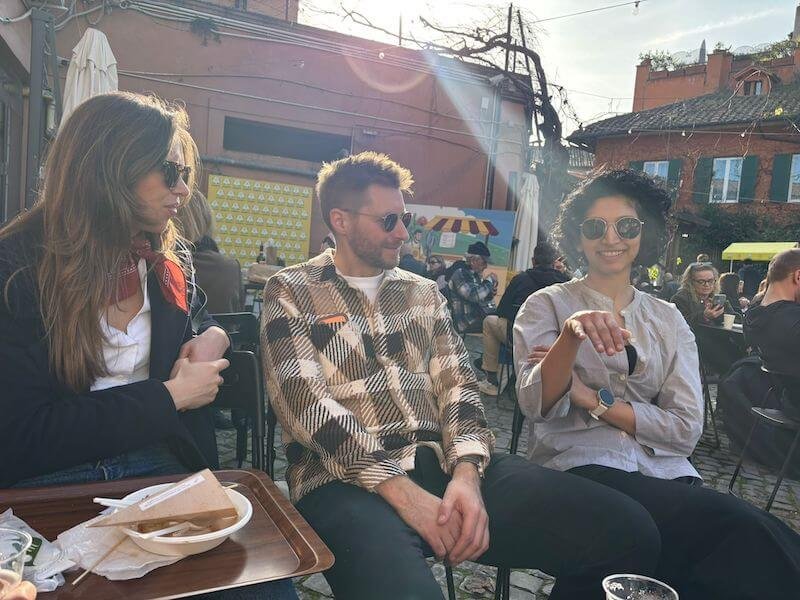 Friends sitting around in the sun at Campagna Amica, one of the best Rome food markets
